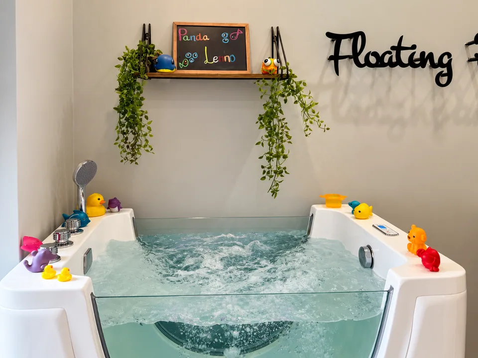 The floating bath at Floating Panda, with toys and trailing plants